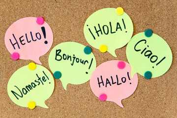 Hello in different languages, speech bubbles on cork board concept