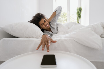 African american woman turns off alarm on the phone