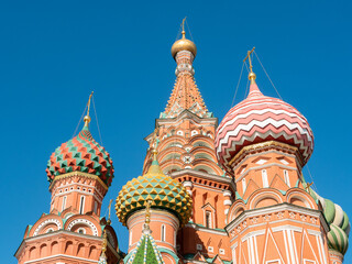 Fototapeta na wymiar Domes of St. Basil's Cathedral with golden crosses on a sunny day. Red Square, Moscow, Russia. Close-up.