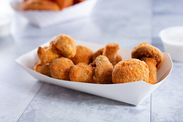 A closeup view of a tray of deep-fried mushrooms.