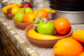 Naklejka premium A view of several terra cotta dishes holding plastic fruit. 