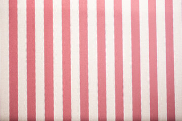 A view of a pastel red and white stripe stitch fabric wall facade, as a background.