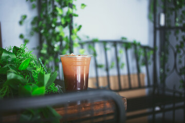 A view of a plastic cup of coffee or milk tea in a faux rustic interior design cafe.
