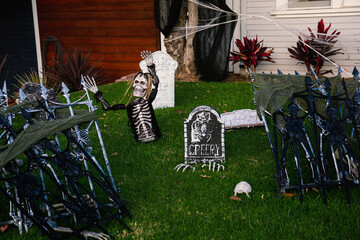 The front lawn is decorated with skeletons, graves and ghosts for the Halloween celebration. Halloween background