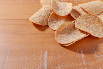 Close-up of some potato chips on a wooden table. Selective focus.