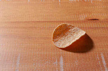Close-up of a delicious potato chips on a wooden table.