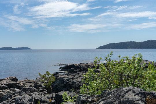 Cobblestone beach, blue sky and still waters on the high coast hiking trail, Sweden