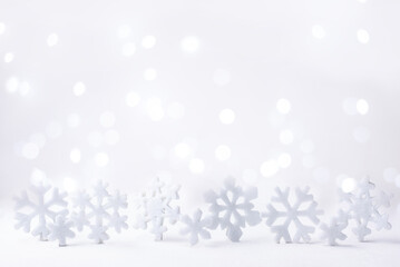 Snowflakes on white background and lights bokeh, Christmas and winter background.