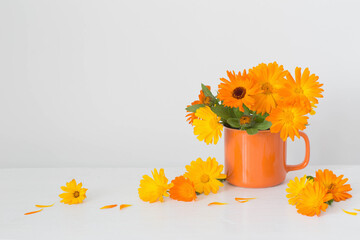 bouquet with orange marigolds   in cup    on white  background