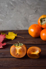 slice the orange persimmon on a wooden background. still-life