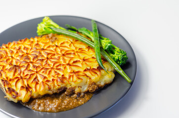 Tender minced lamb with garden veg in a hearty gravy beneath butter mash, typical Shepherd's pie
