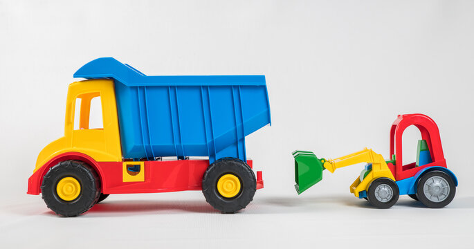 Truck and excavator. Plastic toy multicolored cars isolated on white background.