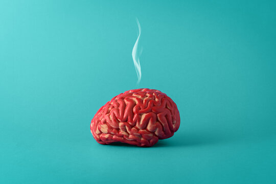 Creative concept of a tired brain on a blue background. Human brain with smoke.