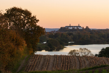Blick auf den Trammer See und das Pl&ouml;ner Schloss im Herbst.	