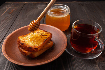 slices of bread drippped with honey and a cup of black tea