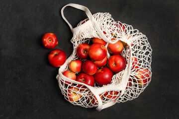 Apples starking in the mesh bag. Sustainability and conscious consuming concept. Top View. Flat Lay. Free space for text.