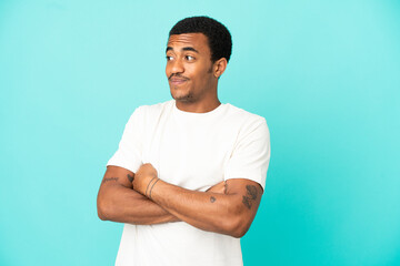 Fototapeta premium African American handsome man on isolated blue background making doubts gesture while lifting the shoulders