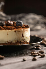 Cake with coffee beans and blueberry on the dark wooden backdrop 