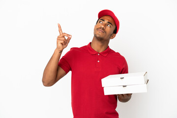 African American pizza delivery man picking up pizza boxes over isolated white wall pointing up a...