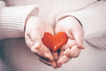 Little girl hans holding a red heart