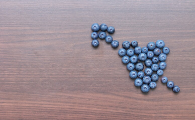 Blueberries laid out on a wooden board in the form of a heart