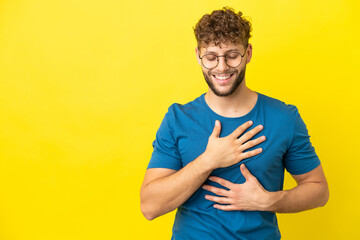 Young handsome caucasian man isolated on yellow background smiling a lot