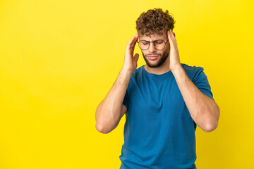 Fototapeta na wymiar Young handsome caucasian man isolated on yellow background with headache