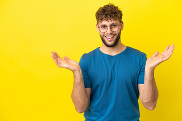 Young handsome caucasian man isolated on yellow background with shocked facial expression