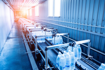 Modern strapping and transporting machine for packaging line at beverage plant.