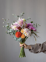 A bouquet of beautiful chrysanthemums in a woman's hand, copy space.