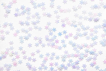 Confetti shiny Christmas snowflakes on a white background.