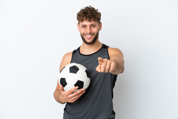Young handsome caucasian man isolated on white background with soccer ball and pointing to the front