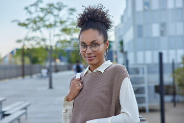 Beautiful schoolgirl enjoys leisure pastime after studying wears round spectacles for vision...