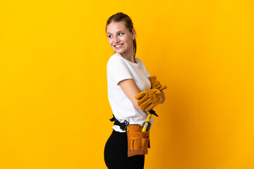 Young electrician woman isolated on yellow background with arms crossed and happy