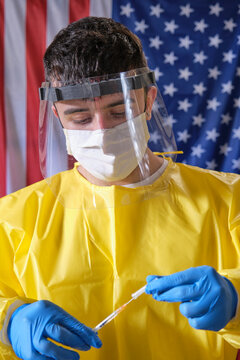 A Young Health Care Worker Looks At The Needle Of A Syringe For Injections