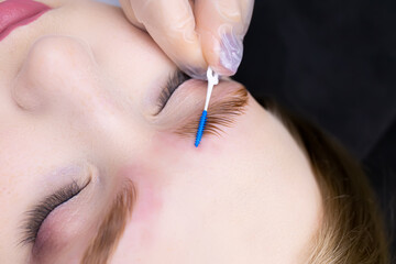 close-up of the eyebrows the master gives shape with a brush after the procedure long-term styling...