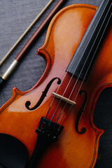 Fototapeta premium Close up image of a new violin on a grey textile surface