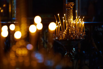 Religion and magic. Candles are burning in a dark church. In the background is a mysterious dim...