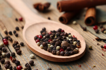 Pepper-and-pepper mixture. Black, red and white peppercorns. mixed of peppercorns in a spoon on a wooden table