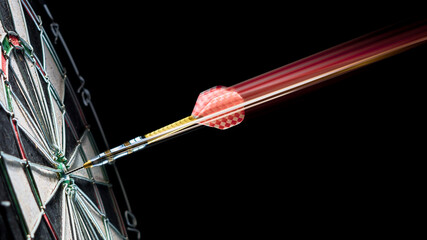 The dart flies into the bullseye dartboard. Blurred dart trail.
