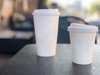 two take away coffee mugs on the table in a cafe with copy space