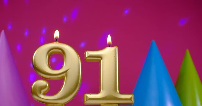 Burning birthday cake candle number 91. Happy Birthday background anniversary celebration concept. Birthday hat in the background