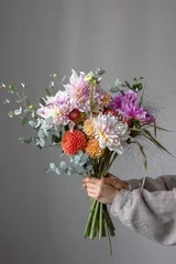 Foto op Aluminium A woman is holding a festive bouquet with chrysathemum flowers in her hands. © puhimec