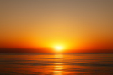 Naklejka premium Bright sunset with large yellow sun under the sea surface, Sunrise over sea