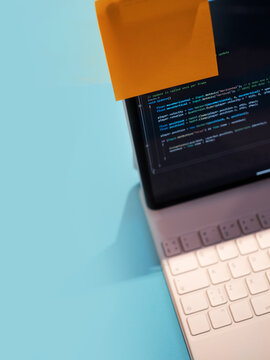 A laptop with a reminder and the program code on the monitor. Time management and schedule in the work of a freelancer or student. process of developing applications or learning programming languages