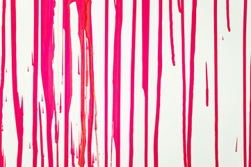 Paint streams on a light surface. A background with red, crimson strips from color. Vertical streams of  red, crimson paint. Background abstract structure