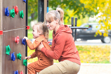 Sportive family practicing rock climbing with children outdoors