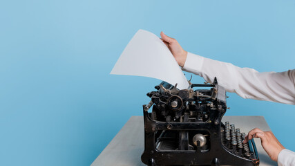 young woman author at a typewriter, writes a text. Retro vintage typewriter close-up