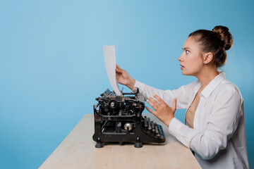 young woman writer at a typewriter is shocked by what she wrote,