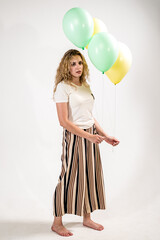 Sad girl with colored balls on a white background. (isolated on white)